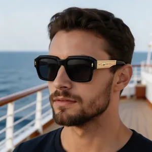 Detail of square polarized sunglasses with ornate gold metal temples on a luxury yacht
