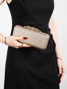 Detail of sparkling champagne gold rhinestone evening clutch bag with bow clasp closure