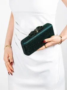 Detailed view of the dark green rhinestone evening clutch with a crystal bow clasp closure