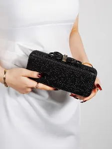 Close-up of elegant black rhinestone evening clutch with crystal-encrusted metal ring clasp