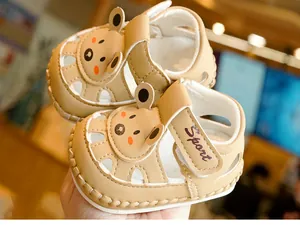 Detail of baby sandal with cartoon bear design and secure velcro closure in khaki