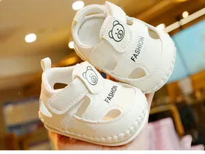 Détail de sandales blanches pour bébés avec motifs ours et fermeture velcro