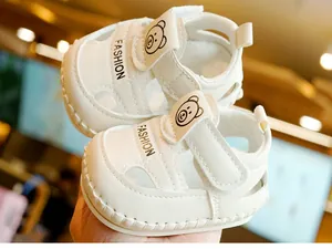 Détail de sandales blanches pour bébé avec motif d'ours et découpes respirantes