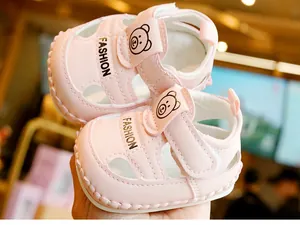 Détail de sandales roses pour bébé avec semelle souple, velcro et motif ours mignon