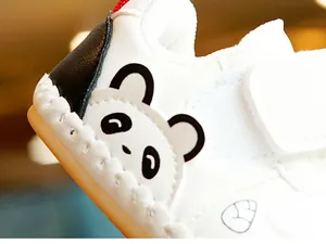 Detail of baby walking shoe with panda heel design and white synthetic leather