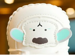 Close-up of white leather baby shoe with cute cartoon dog embroidery and wavy stitching