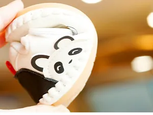 Macro shot showing the ultra-flexible soft sole of a panda baby shoe being folded easily