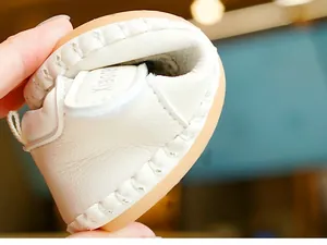 Vue détaillée de chaussures souples pour bébé en cuir blanc avec semelle en caoutchouc