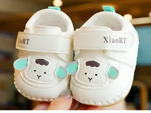 Detailed close-up of soft white baby shoes with cute sheep motif and velcro strap closure