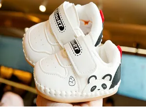 Detail of baby walking shoes with panda print, faux leather texture and velcro strap