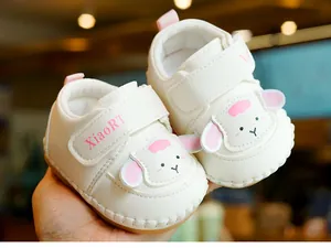 Detailed view of white baby walking shoes with cute cartoon sheep design and soft anti-slip sole