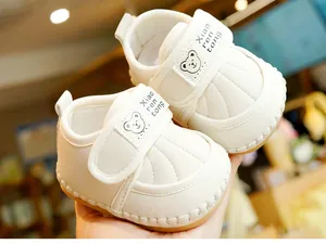 Detail of baby walking shoes with bear pattern, velcro strap and soft rubber sole