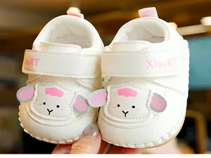 Detail of baby walking shoes with cute pink sheep embroidery and velcro strap
