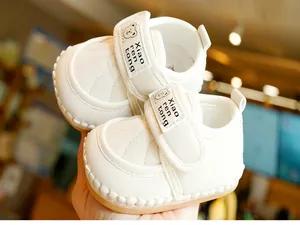 Close-up of baby walking shoes with non-slip rubber soles and cute bear pattern