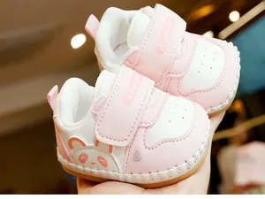 Detailed close-up of pink baby walker shoes with cartoon bear and secure velcro strap