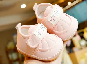 Close-up of pink soft-soled baby walking shoes with cute cartoon bear and velcro strap