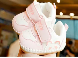Detail of baby walking shoes featuring breathable pink panda design and velcro strap