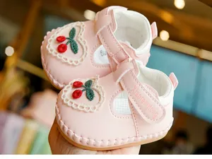 Gros plan détaillé de chaussures de princesse rose bébé avec broderie cerise