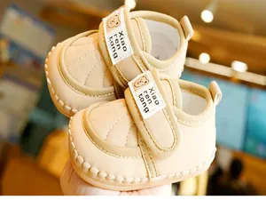 Close-up of baby walking shoes with non-slip soft soles and cute bear velcro strap