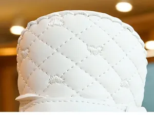 Close-up of white quilted leather with heart embroidery on baby shoe detail