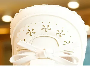 Close-up of baby girl shoes with hollow floral patterns and white decorative bows