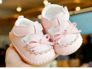 Close-up of pink baby shoes with sequins, decorative bows and non-slip soft rubber soles