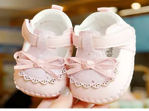 Macro detail of pink glitter baby princess shoes with delicate double bow and soft sole