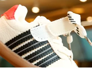 Close-up of baby walking shoes showing white leather texture and non-slip rubber soles