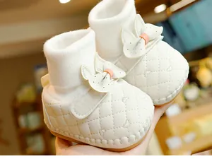 Close-up of baby warm sock boots with heart embroidery, bow detail and non-slip sole