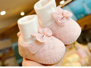 Detail of pink baby walking shoes featuring soft soles, cute bow, and bunny ears design