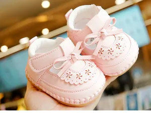 Close-up of pink baby Mary Jane shoes featuring a bow, laser-cut petals and soft non-slip sole