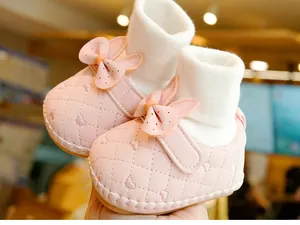 Close-up of pink baby walker shoes with heart embroidery and rabbit ear bow details