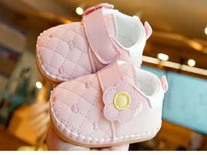 Detail of pink baby walking shoes featuring quilted heart patterns and 3D flower decoration