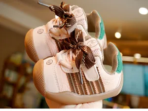 Close-up of pink leather toddler shoes with brown plaid bows and rubber soles
