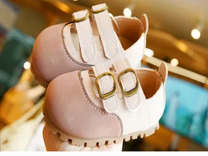 Detail of pink toddler walking shoes featuring double bronze buckles and non-slip rubber soles