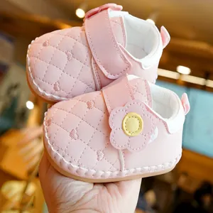Pink infant walking shoes with heart stitching and decorative floral velcro strap