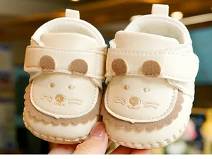 Detail of cream baby walking shoes with cute mouse face and soft PU leather texture