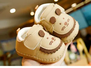 Detail of baby walking shoes with cute lion face design and velcro strap closure
