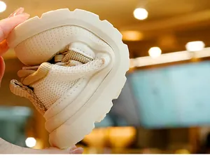 Gros plan montrant la semelle souple et la maille respirante des chaussures bébé beige
