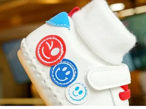 Détail de chaussures de marche bébé avec col en maille blanc et lacets rouges élastiques