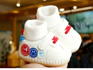 Détail de chaussure de marche souple pour bébé avec lacets rouges et bride velcro