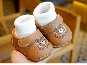 Detailansicht brauner Baby-Lauflernschuhe mit Strickbund und Cartoon-Bären-Stickerei