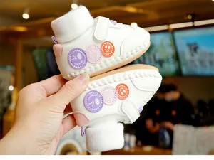 Détails de chaussures pour bébé en cuir blanc avec écussons souriants brodés colorés