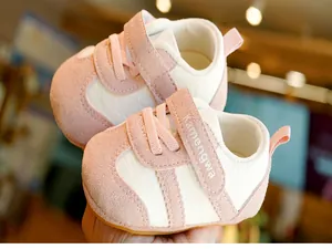 Close-up of pink and white baby walking shoes with soft soles and velcro strap