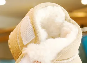Detailansicht des dicken weißen Kunstfellfutters und beigen Wildleders der Babyschuhe