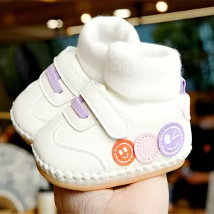 Chaussures de marche blanches pour bébés avec col en tricot et patchs souriants colorés