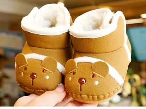 Close-up of brown baby winter boots featuring plush fleece lining and cute bear face design