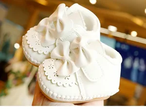 Detailansicht des weichen Plüschfutters und der rutschfesten Sohle der weißen Babyschuhe