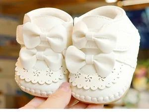 Detail von warmem Plüschfutter und weißer Schleife auf weichen Babyschuhen