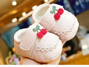 Détail de chaussures bébé roses doublées avec broderie cerise et texte love you
